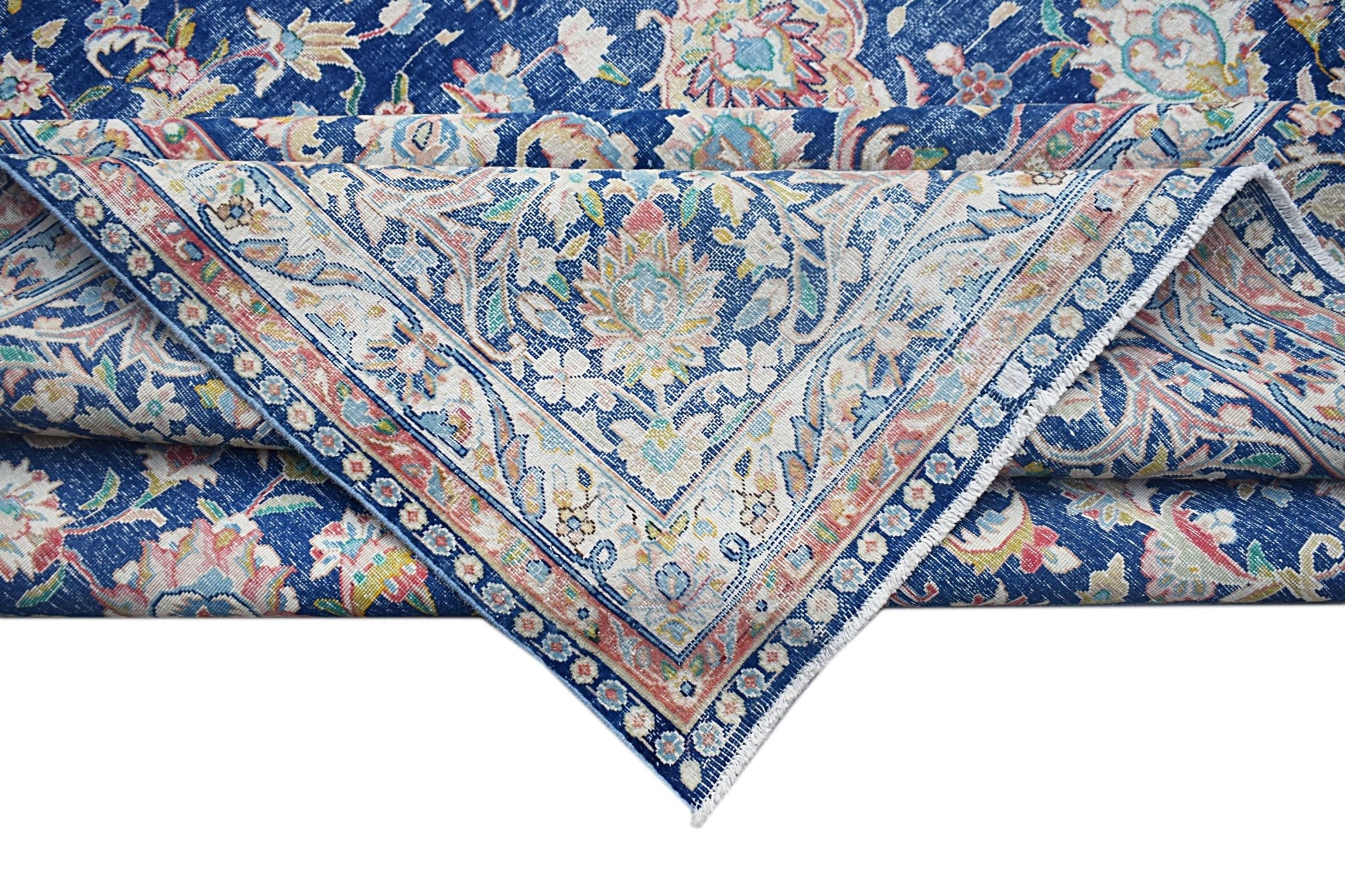 A vintage Persian Kerman rug featuring a blue field with intricate floral patterns and a medallion.