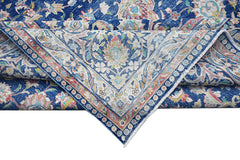 A vintage Persian Kerman rug featuring a blue field with intricate floral patterns and a medallion.
