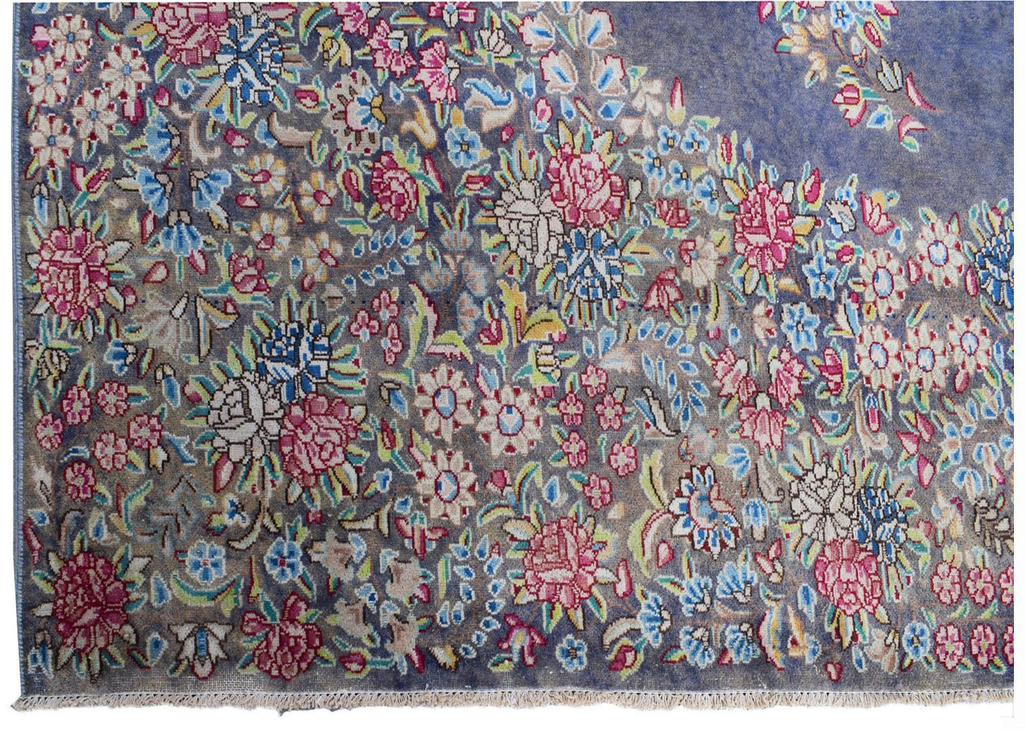 A vintage Persian Kerman rug featuring an intricate floral pattern in pink and blue on a grey field.