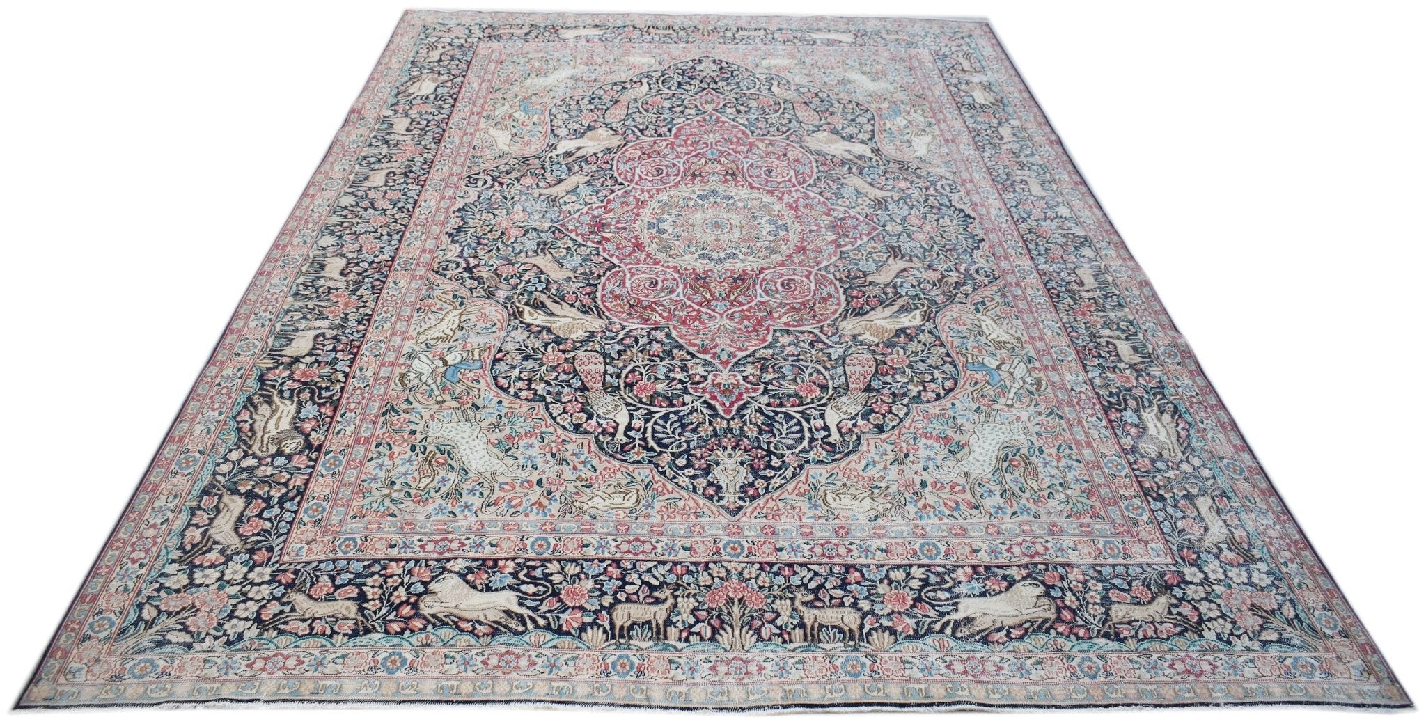 A vintage Persian Kerman rug featuring a central medallion and intricate floral animal motifs.