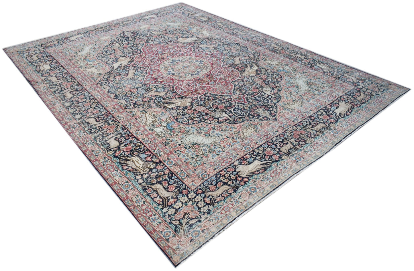 A vintage Persian Kerman rug featuring an intricate central medallion and detailed floral motifs.