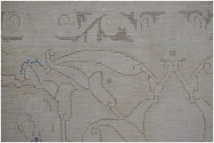A close-up of a vintage Persian Kerman rug featuring intricate, light-toned floral line work.