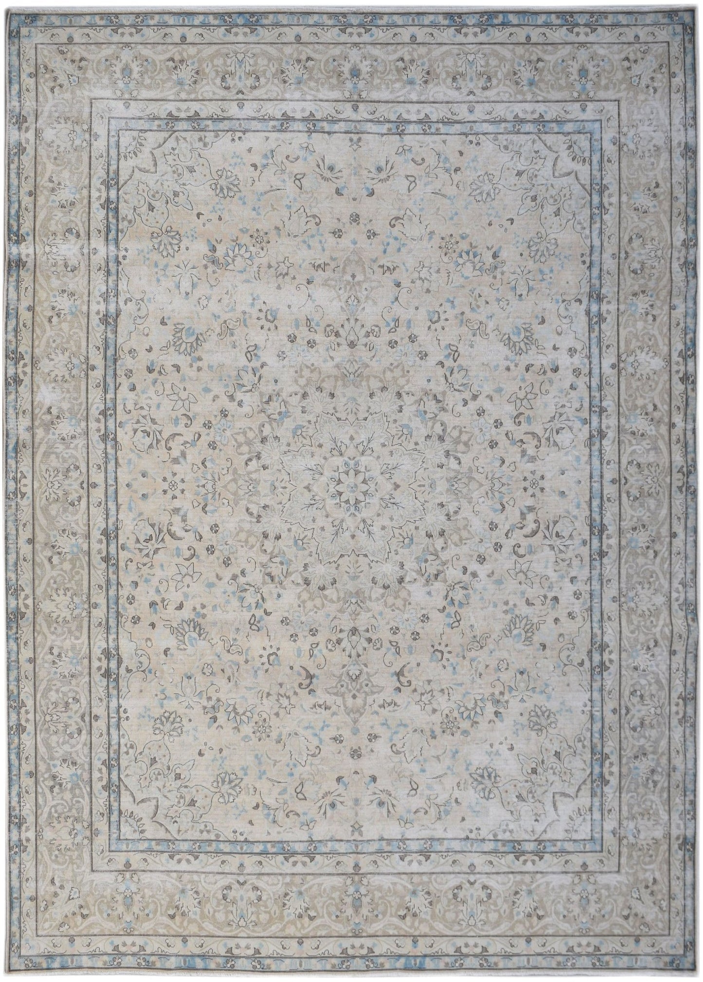 A vintage Persian Kerman rug featuring a central floral medallion in soft beige and blue tones.
