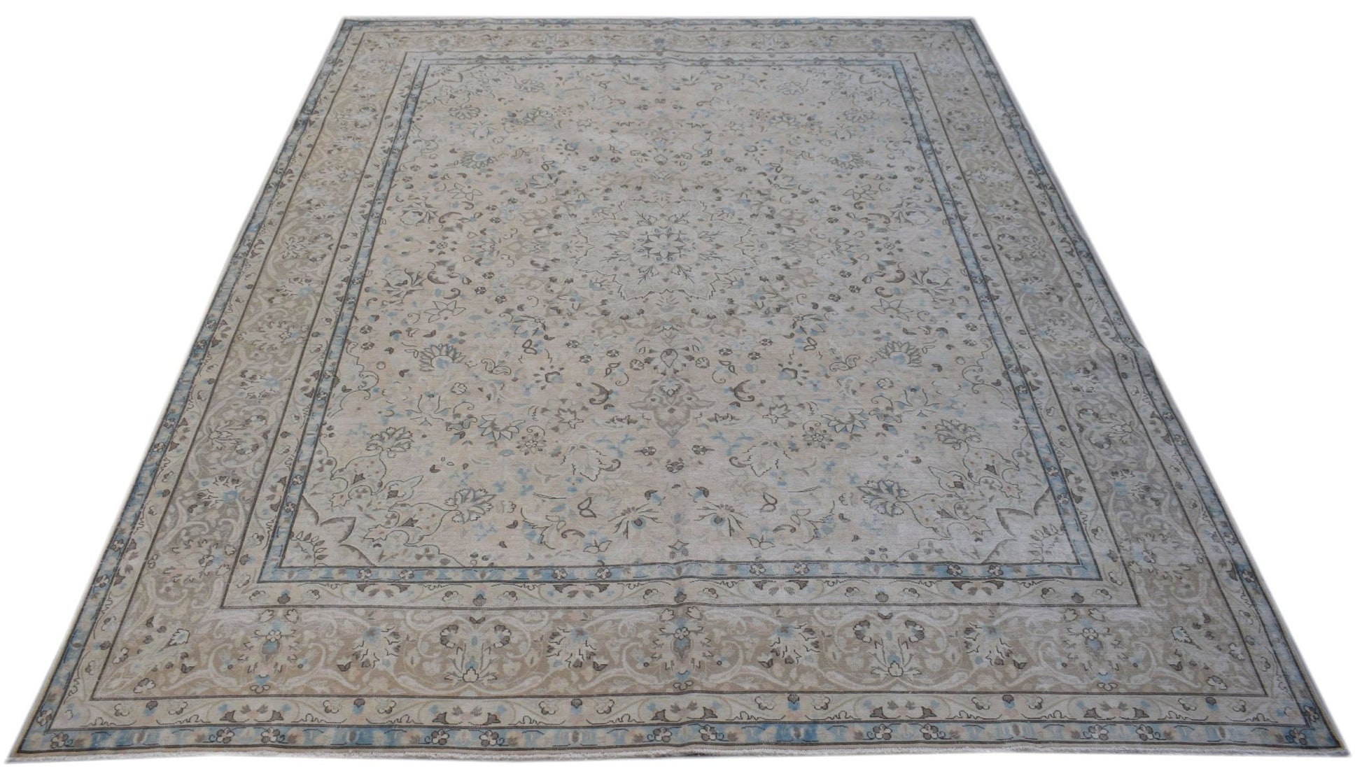 A vintage Persian Kerman rug featuring a central medallion and intricate floral patterns in soft tones.