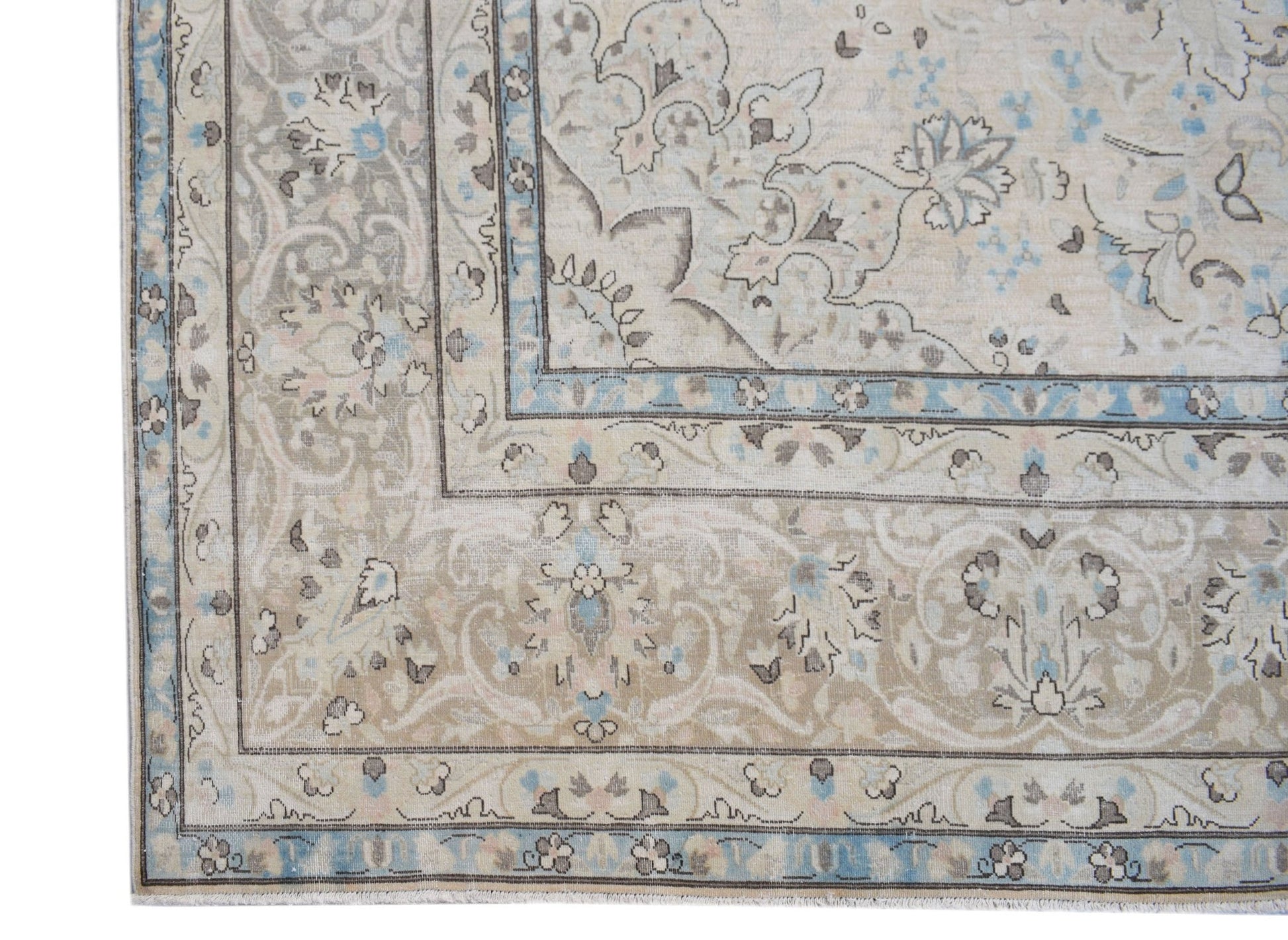 A vintage Persian Kerman rug featuring an intricate floral pattern in soft blue and beige tones.