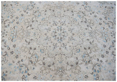 A vintage Persian Kerman rug featuring a central floral medallion in soft beige and blue tones.