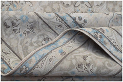 A vintage Persian Kerman rug featuring a soft floral pattern in blue and beige tones.