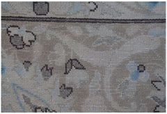 Close-up of a vintage Persian Kerman rug featuring intricate floral motifs in soft neutral tones.