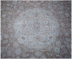 A vintage Persian Kerman rug featuring a central floral medallion in soft pink and blue tones.