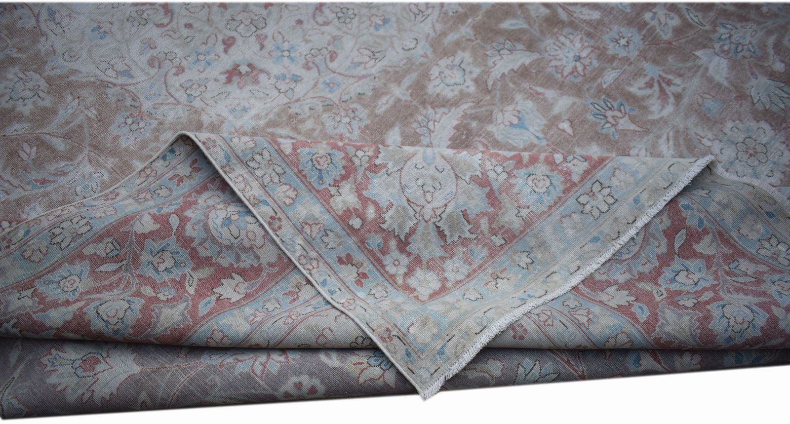 A vintage Persian Kerman rug featuring a floral medallion design in soft pink and blue tones.