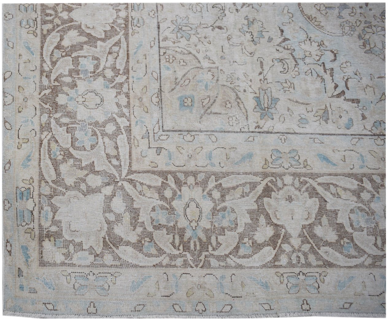 A vintage Persian Kerman rug featuring an intricate floral pattern in soft blue and brown tones.
