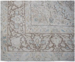 A vintage Persian Kerman rug featuring an intricate floral pattern in soft blue and brown tones.