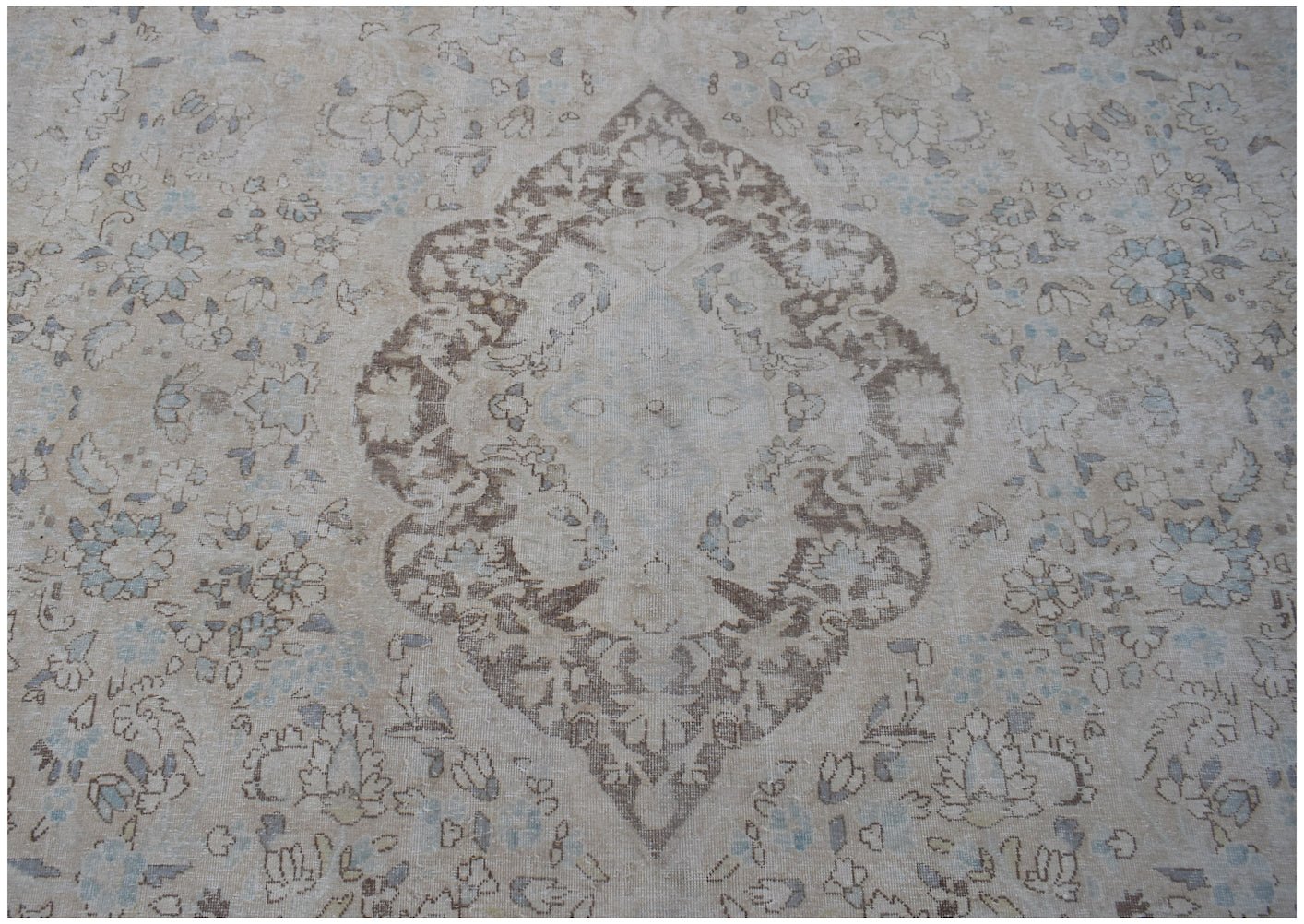 A vintage Persian Kerman rug featuring a central medallion surrounded by intricate floral patterns.