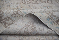 A vintage Persian Kerman rug featuring a soft beige palette with intricate floral patterns.