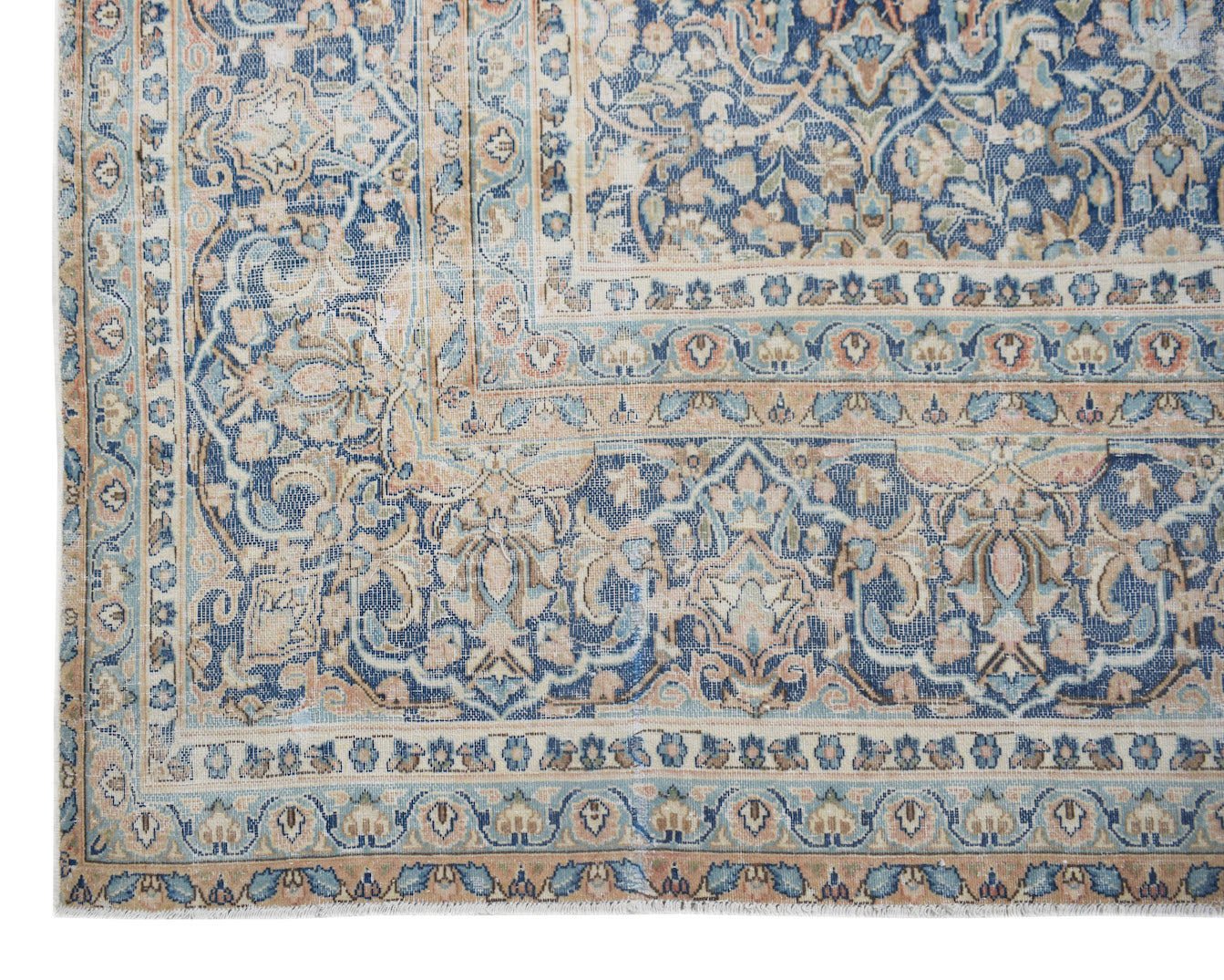 A vintage Persian Kerman rug featuring an intricate floral pattern in shades of blue and beige.