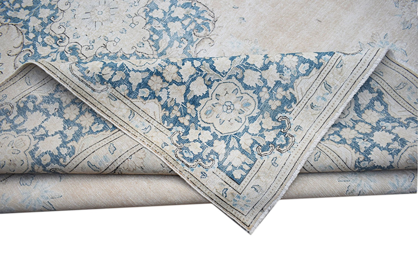 A vintage Persian Kerman rug featuring a blue and cream floral medallion pattern.