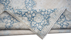 A vintage Persian Kerman rug featuring a blue and cream floral medallion pattern.