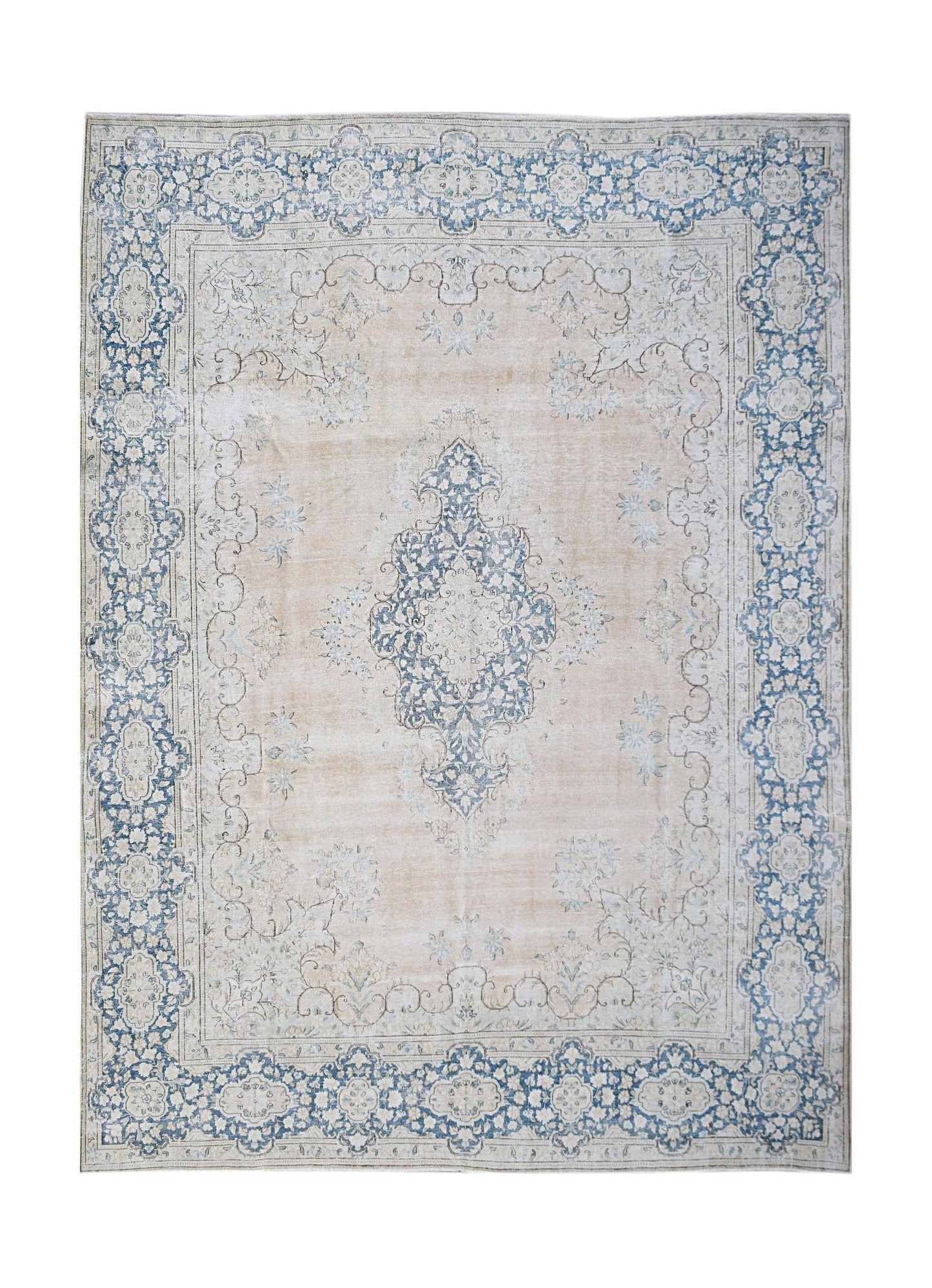 A vintage Persian Kerman rug featuring a central blue medallion on a soft beige floral field.