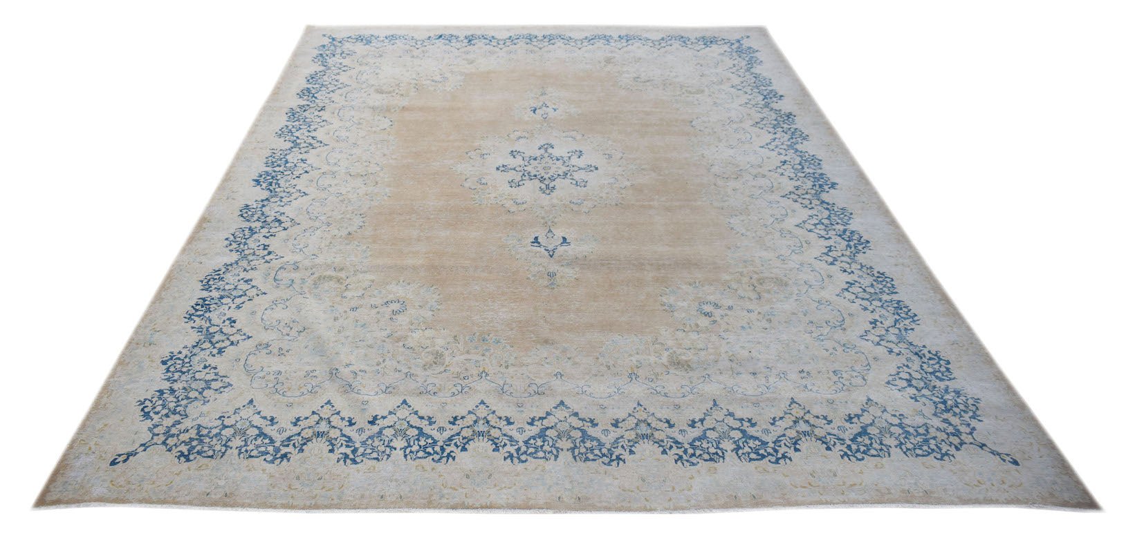 A vintage Persian Kerman rug featuring a central medallion and floral border in blue and beige.