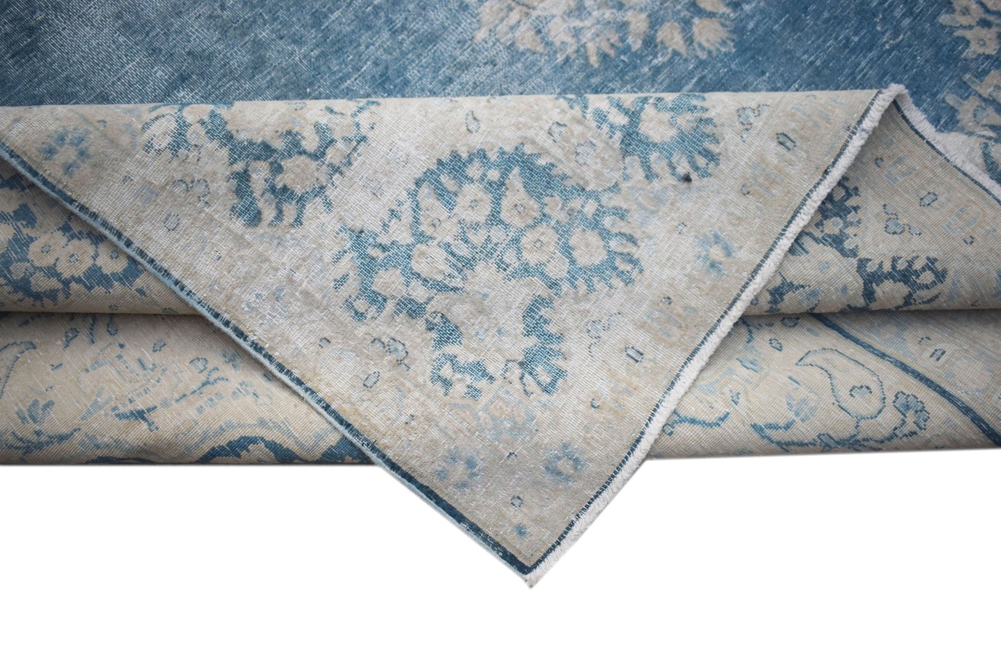 A vintage Persian Kerman rug featuring a blue and cream floral medallion pattern.
