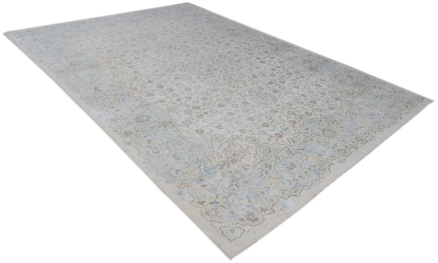 A vintage Persian Kerman rug featuring an intricate floral pattern in soft blue and beige tones.