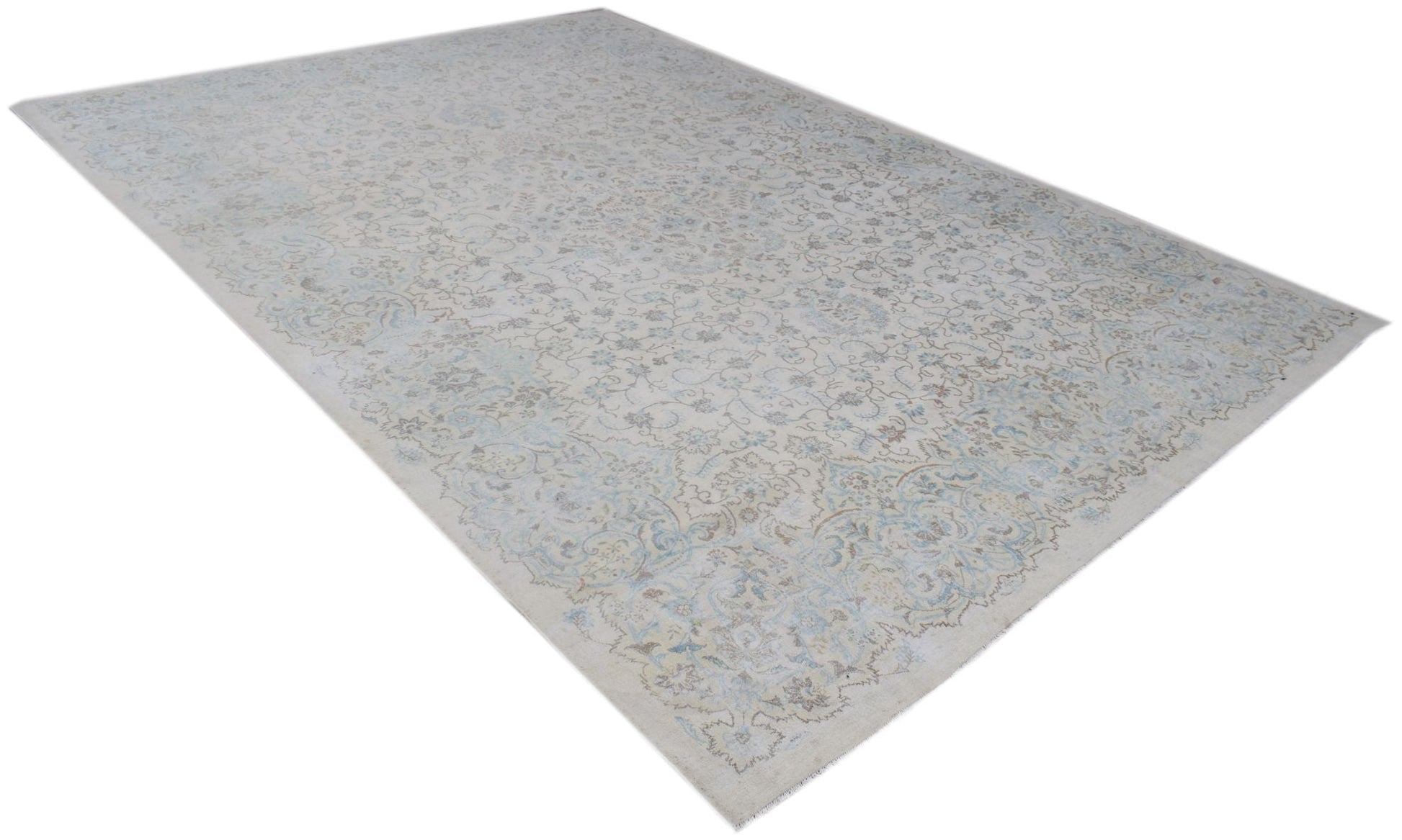A vintage Persian Kerman rug featuring an intricate floral pattern in soft blue and beige tones.