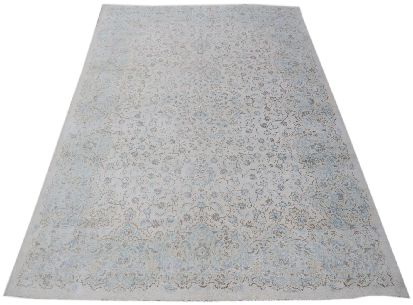A vintage Persian Kerman rug featuring an intricate floral medallion design in soft blue and beige.
