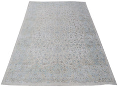 A vintage Persian Kerman rug featuring an intricate floral medallion design in soft blue and beige.