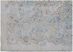 A vintage Persian Kerman rug featuring intricate floral patterns in soft blue and beige tones.