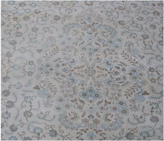 A vintage Persian Kerman rug featuring an intricate floral medallion in soft blue and brown tones.