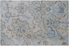 A vintage Persian Kerman rug featuring intricate floral patterns in soft blue and beige tones.