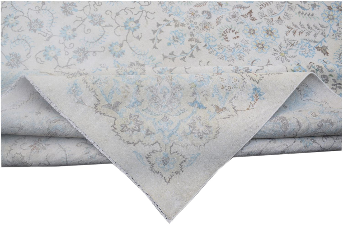 A vintage Persian Kerman rug featuring a light cream background with intricate blue floral patterns.