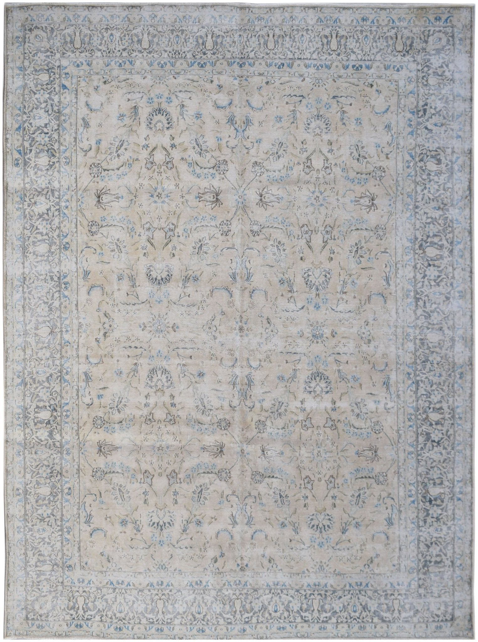 A vintage Persian Kerman rug featuring an intricate floral pattern in soft blue and beige tones.