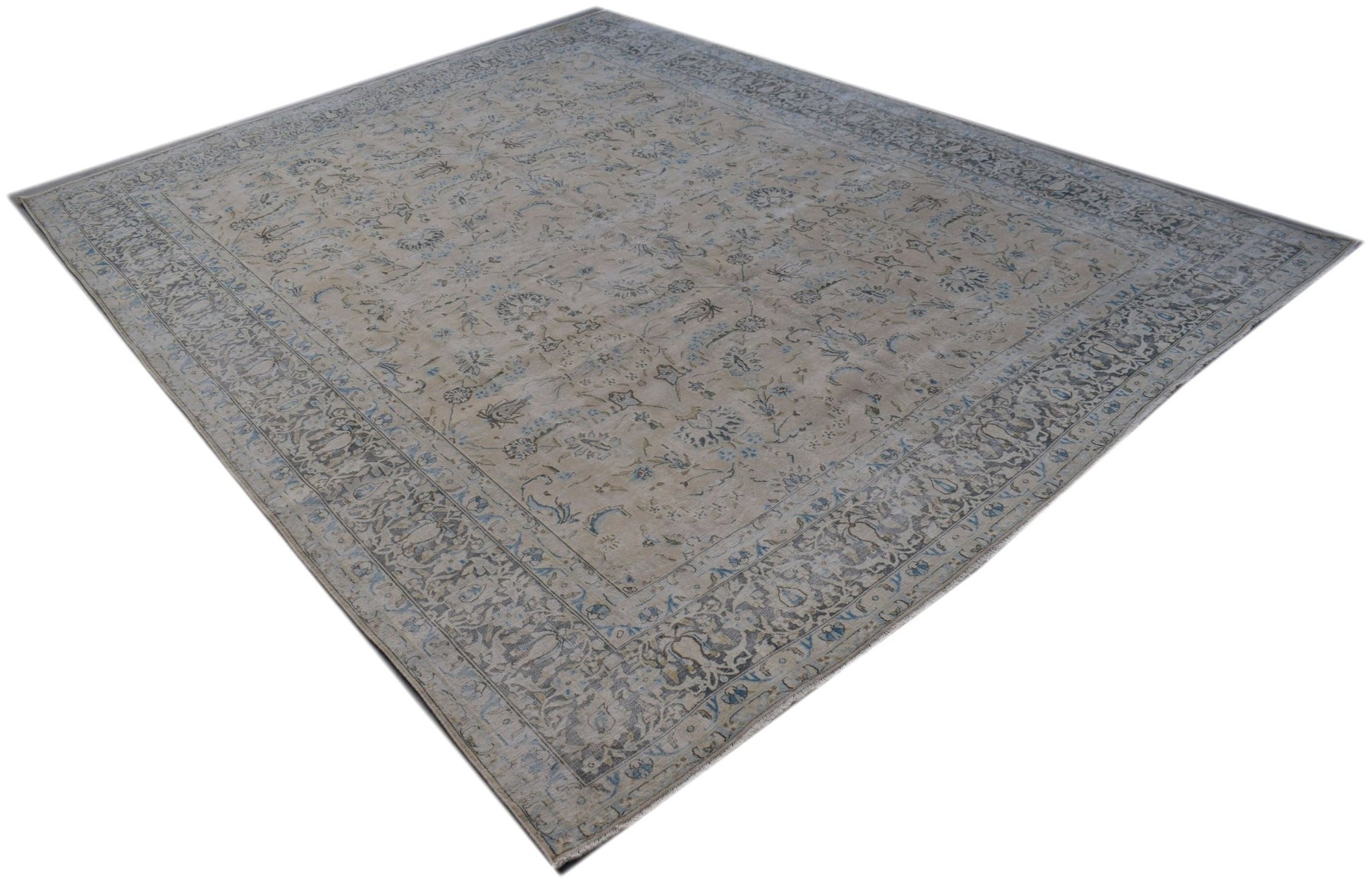 A vintage Persian Kerman rug featuring an intricate floral pattern in soft blue and beige tones.