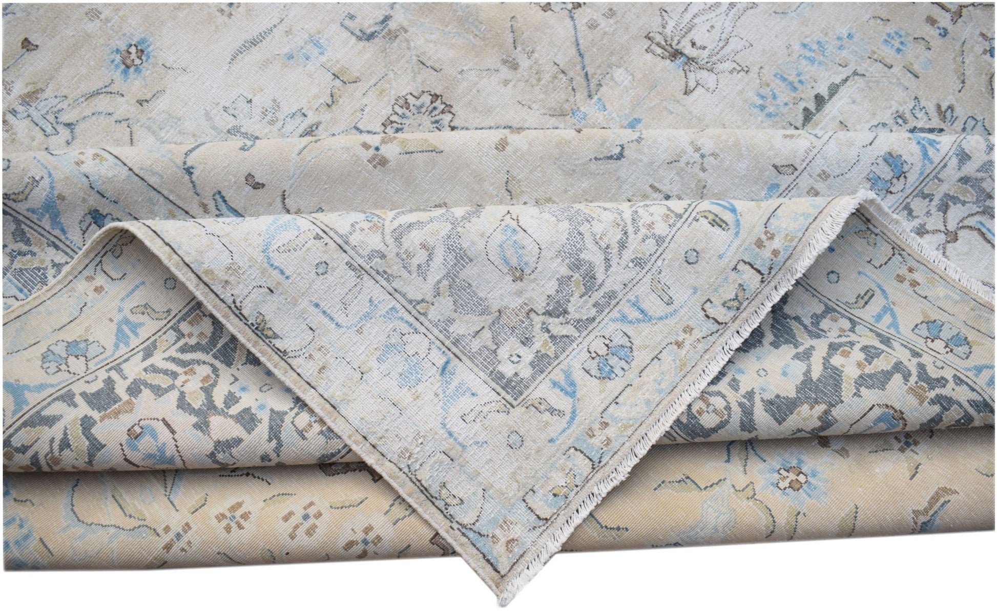 A vintage Persian Kerman rug featuring a light beige field with intricate blue floral patterns.