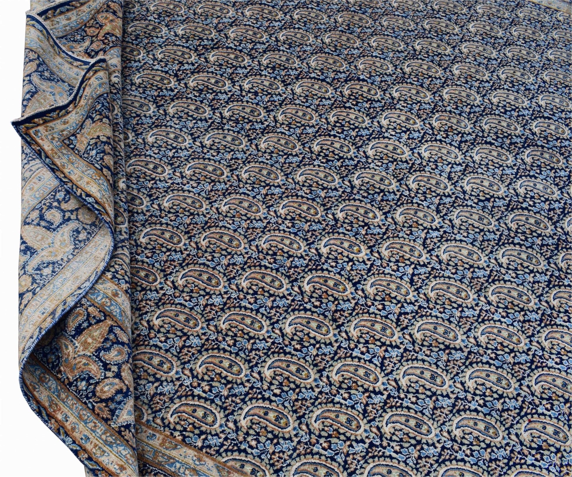 A vintage Persian Kerman rug featuring a dense, repeating paisley pattern in blue and cream tones.