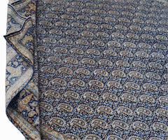 A vintage Persian Kerman rug featuring a dense, repeating paisley pattern in blue and cream tones.