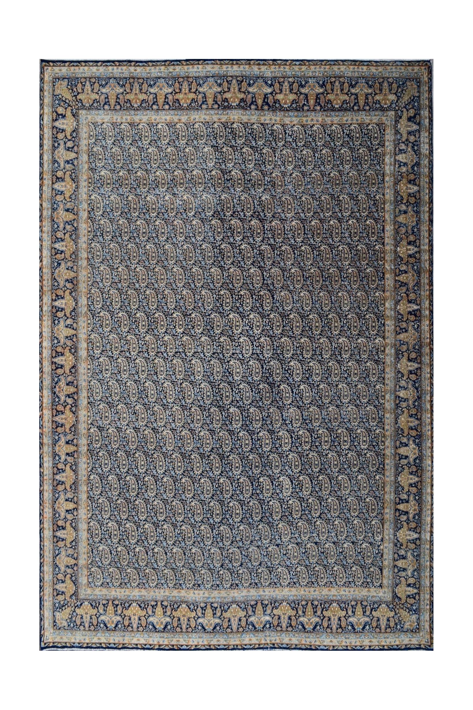 A vintage Persian Kerman rug featuring an intricate all-over paisley pattern in blue and gold.