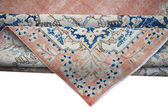 A vintage Persian Kerman rug featuring a floral medallion design in shades of peach and blue.