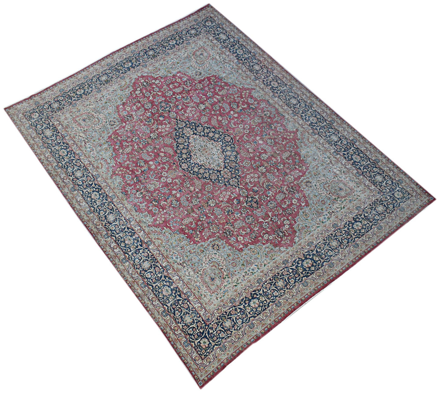 A vintage Persian Kerman rug featuring a central medallion surrounded by intricate floral patterns.