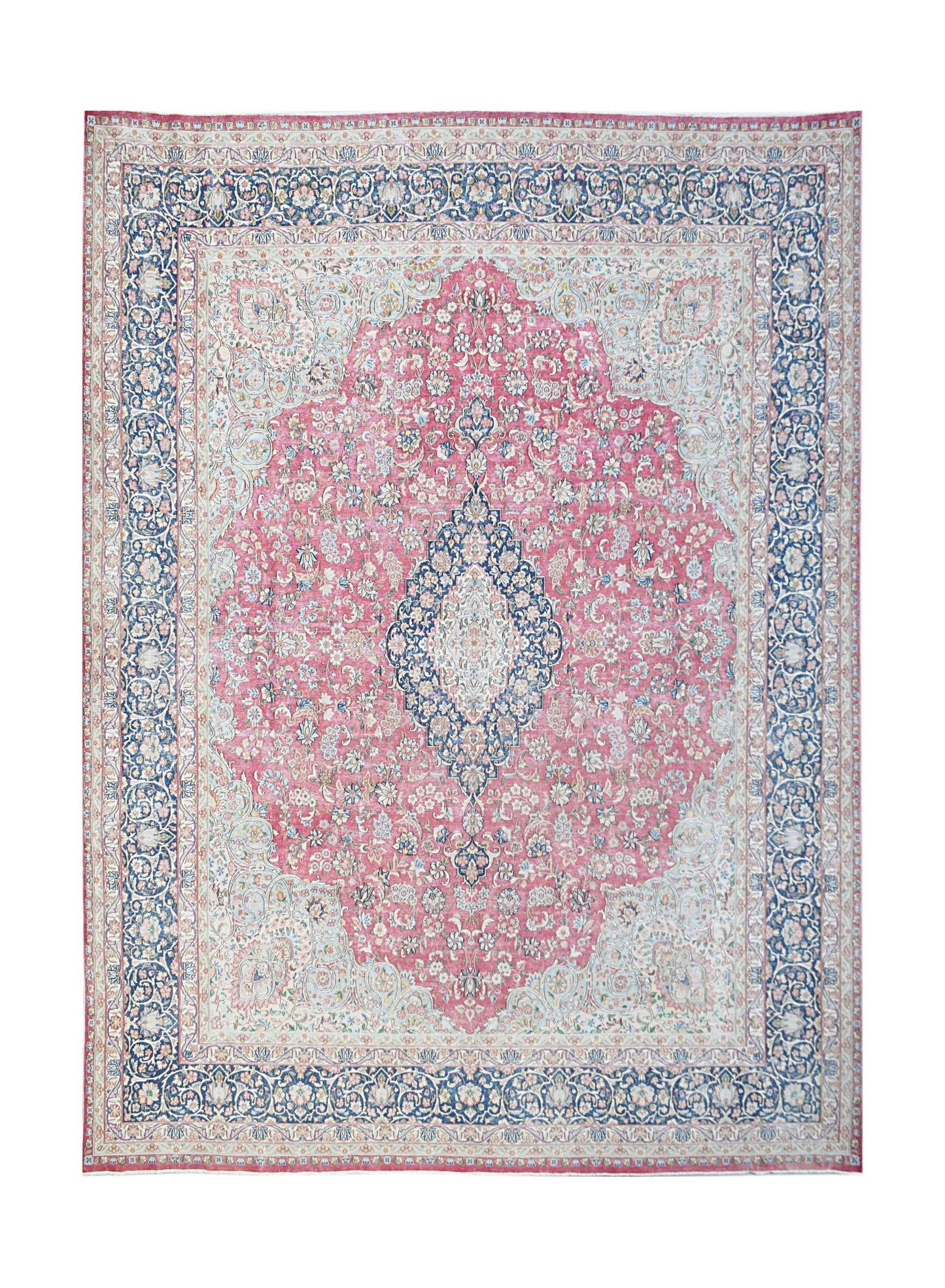 A vintage Persian Kerman rug featuring a central medallion and intricate floral patterns in pink and blue.