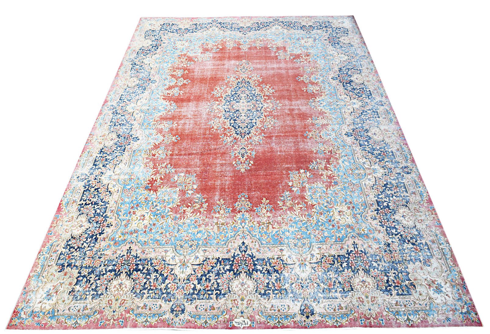 A vintage Persian Kerman rug featuring a central medallion and intricate floral patterns in red.