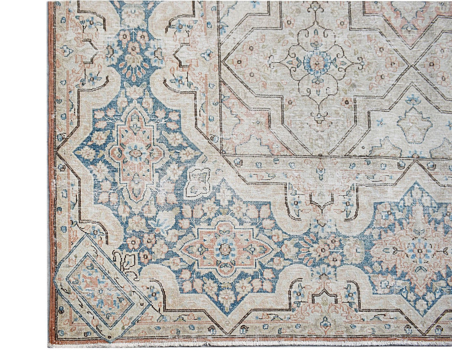 Vintage Persian Kerman rug featuring a beige field with intricate blue and pink floral motifs.