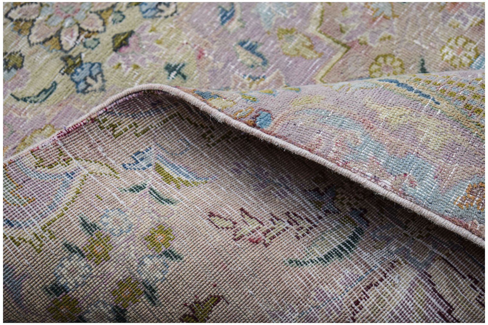 A close-up view of a vintage Persian Kerman runner showing its intricate floral pattern and weave.