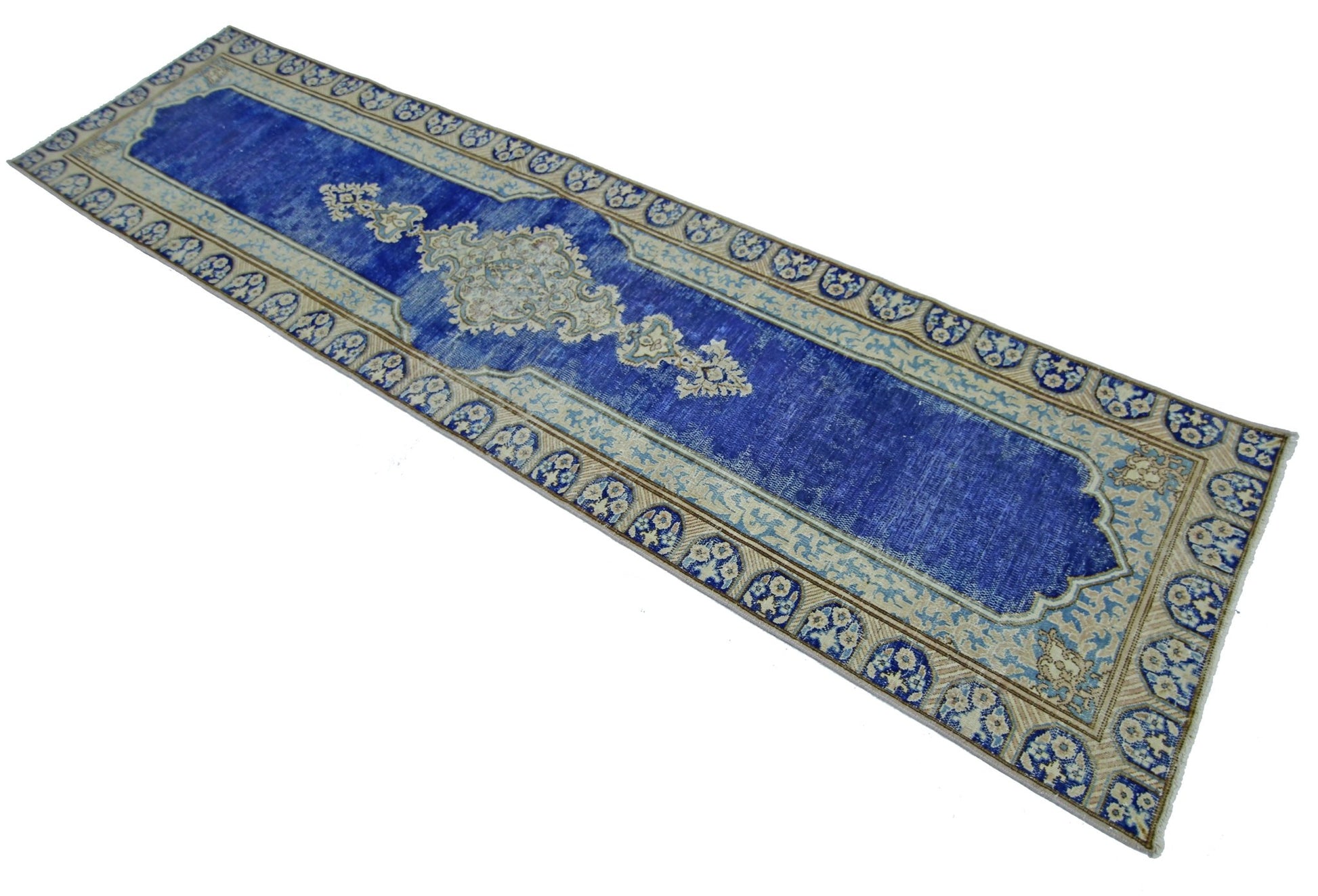 A vintage Persian Kerman runner featuring a central medallion on a deep blue field with floral borders.