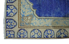 A vintage Persian Kerman runner featuring a deep blue field with intricate floral border patterns.