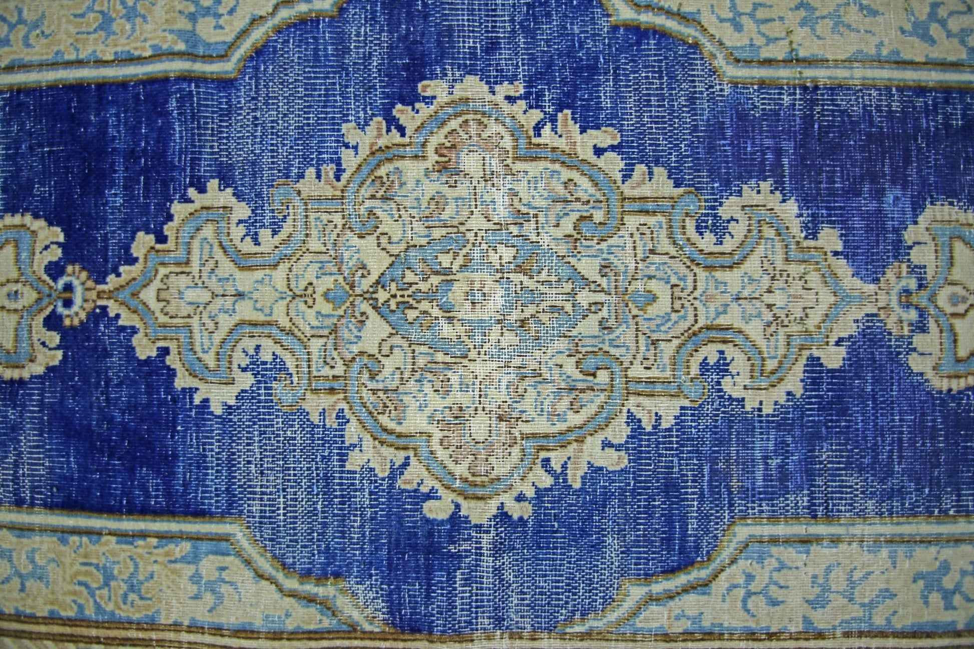 A vintage Persian Kerman runner featuring an intricate central medallion on a deep blue field.