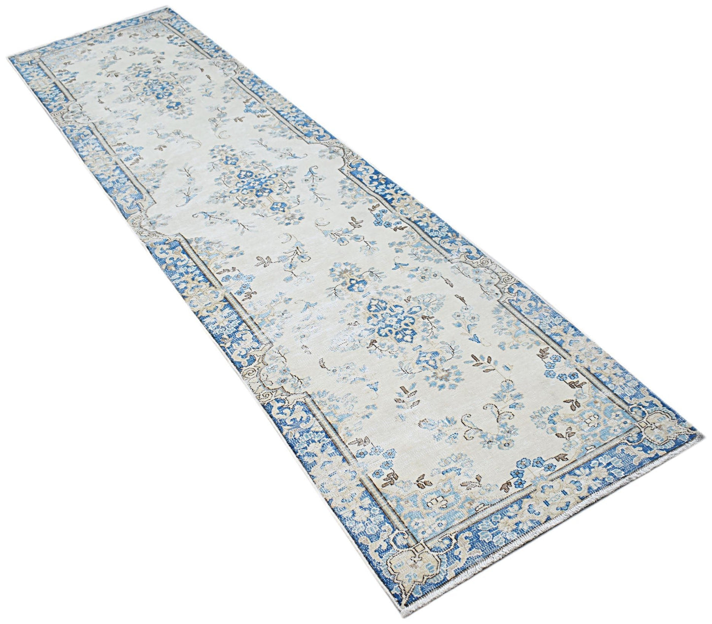 A vintage Persian Kerman runner featuring a blue and cream floral medallion pattern.