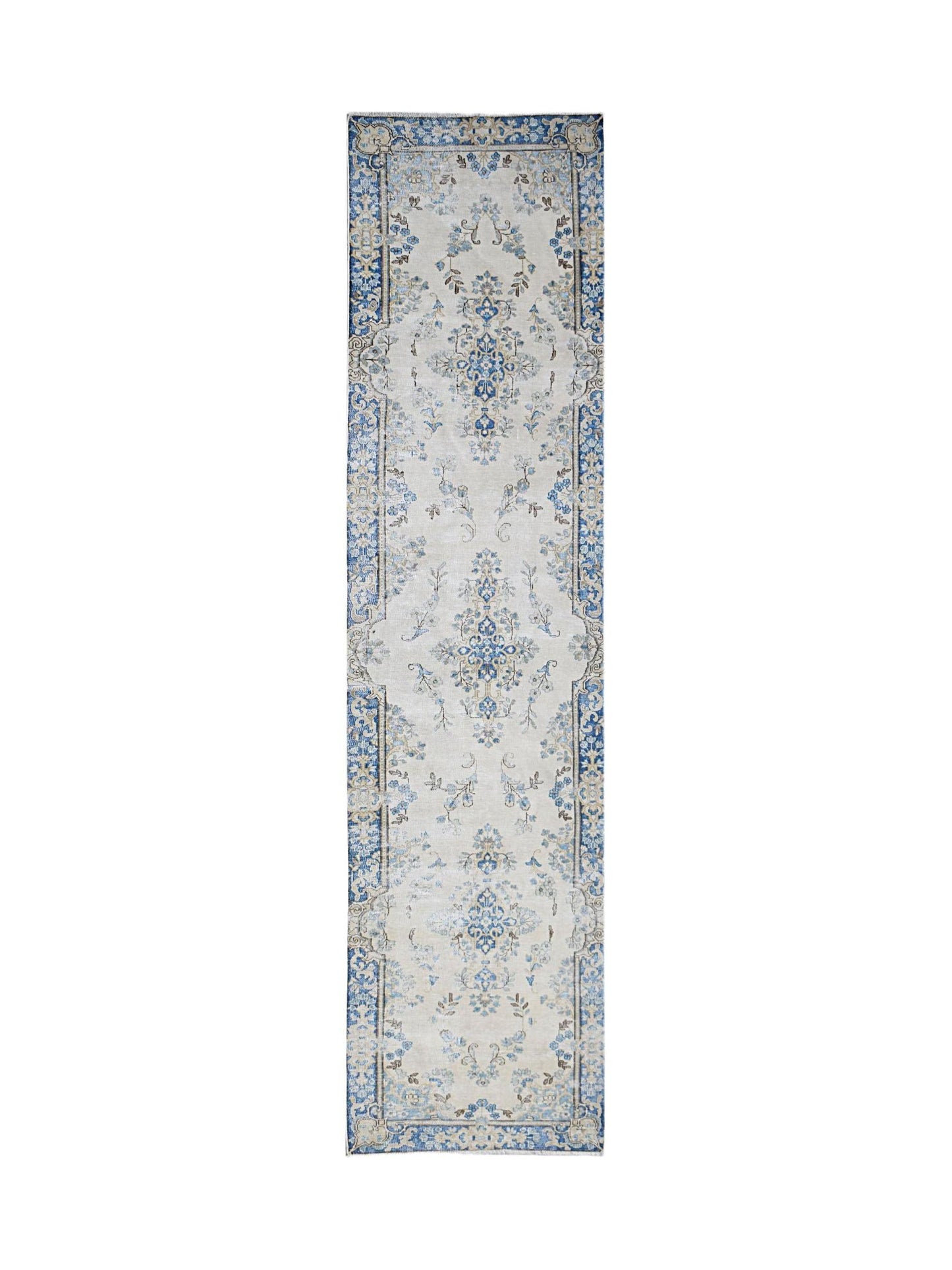 A vintage Persian Kerman runner rug featuring a blue floral medallion pattern on a cream background.