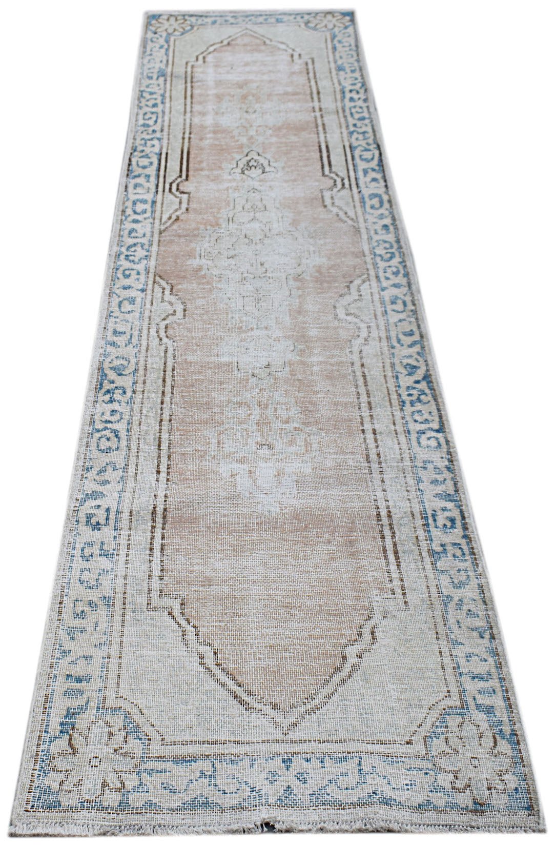 A vintage Persian Kerman runner featuring a central medallion and floral motifs in muted tones.